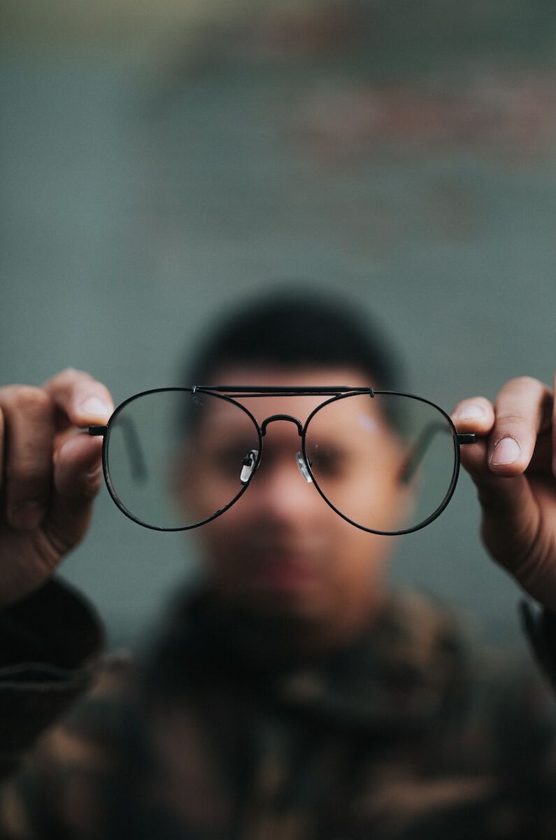 Photo by Nathan Dumlao man holding eyeglasses